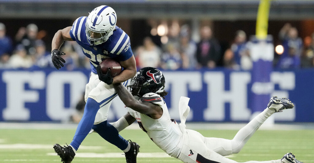 Houston Texans safety Calen Bullock (2) brings down Indianapolis Colts running back Jonathan Taylor (28) on Sunday, Nov. 30, 2025, during a game at Lucas Oil Stadium in Indianapolis.
