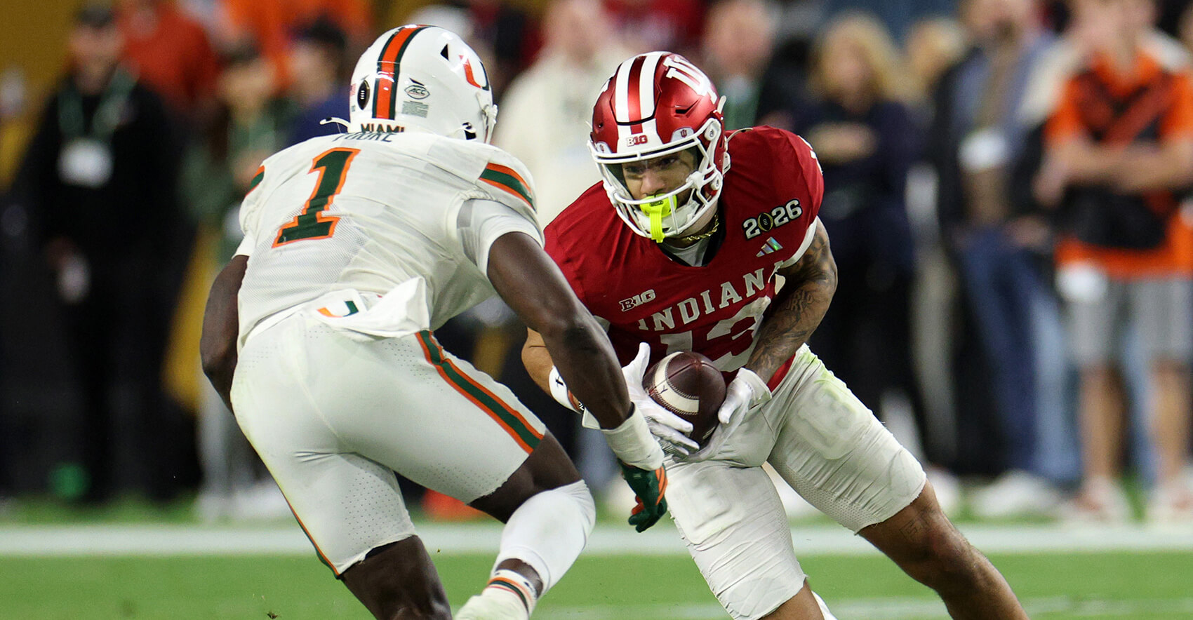 Jan 19, 2026; Miami Gardens, FL, USA; Indiana Hoosiers wide receiver Elijah Sarratt (13) makes a catch against Miami Hurricanes linebacker Mohamed Toure (1) in the second half during the College Football Playoff National Championship game at Hard Rock Stadium. Mandatory Credit: Nathan Ray Seebeck-Imagn Images