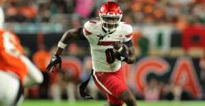 Oct 17, 2025; Miami Gardens, Florida, USA; Louisville Cardinals wide receiver Chris Bell (0) carries the football against the Miami Hurricanes during the first quarter at Hard Rock Stadium. Mandatory Credit: Sam Navarro-Imagn Images