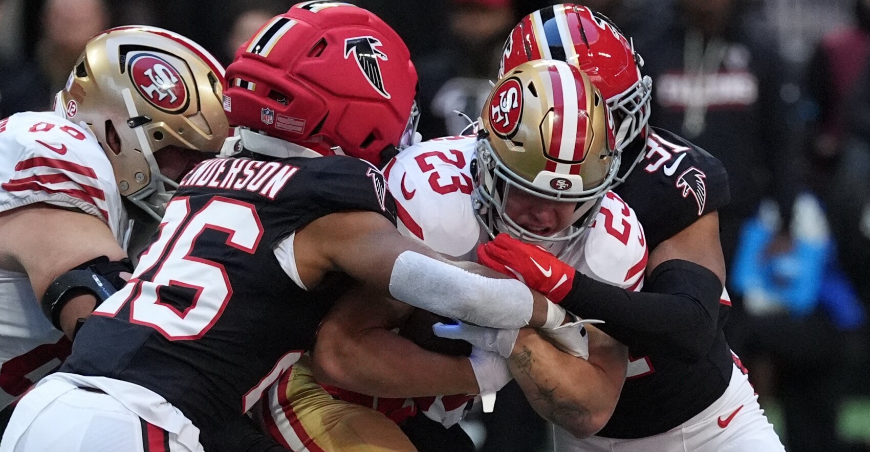 San Francisco 49ers running back Christian McCaffrey (23) is tackled by Atlanta Falcons cornerback C.J. Henderson (26) and safety Xavier Watts (31) during the first quarter at Mercedes-Benz Stadium.